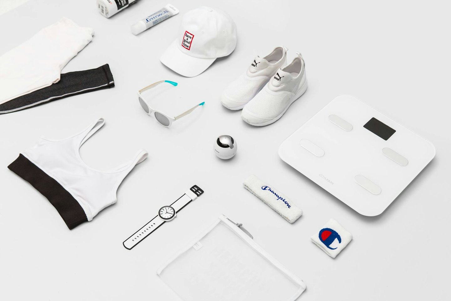Flat lay of white and black athletic wear and fitness tech.