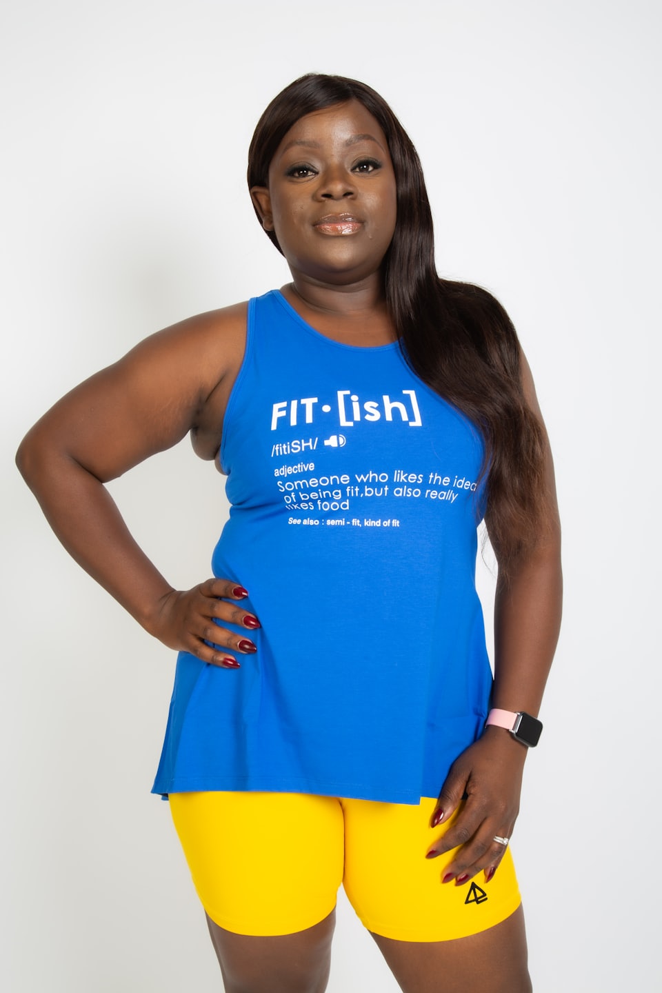 Woman in a blue tank top posing with her hand on her hip.